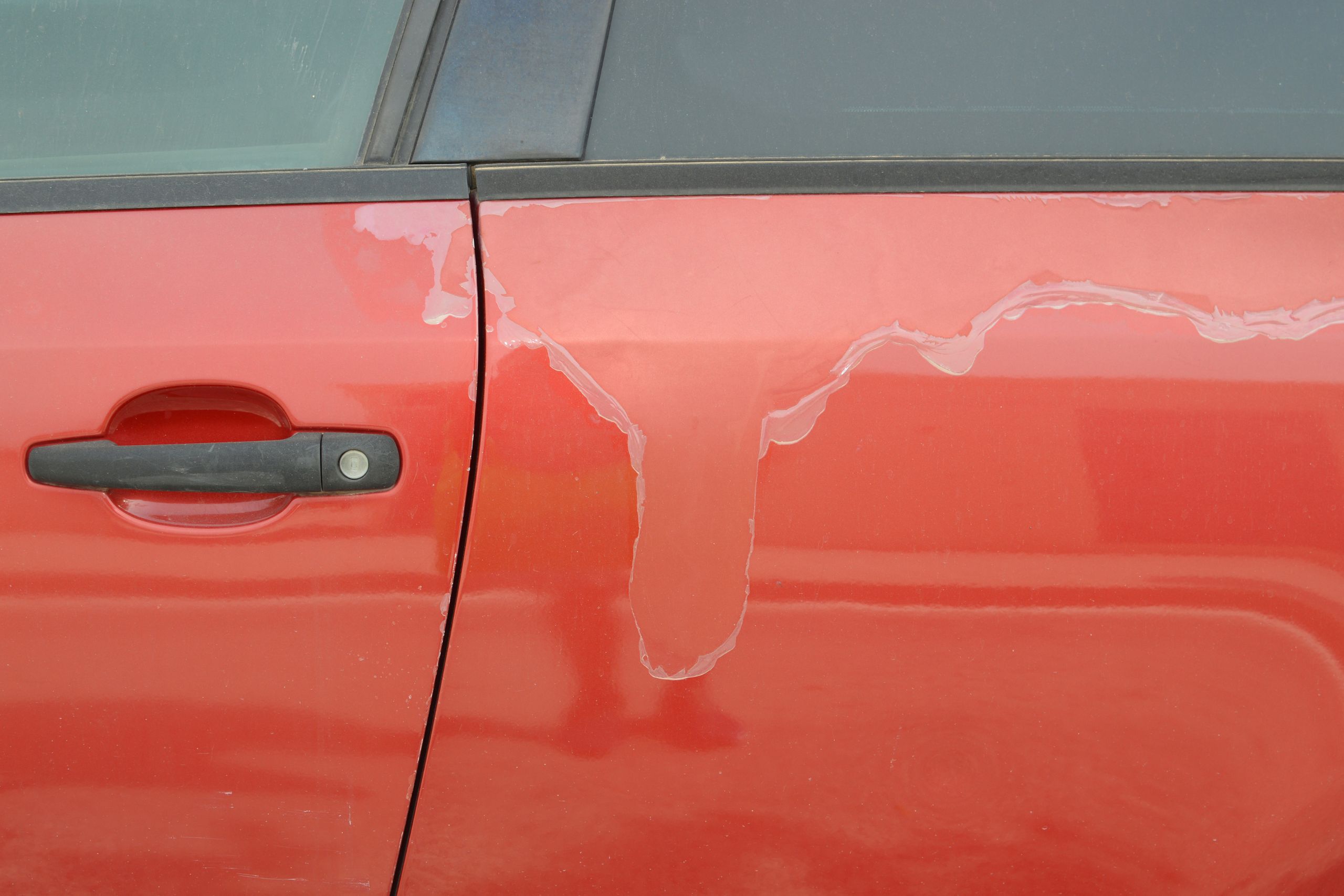 temperature affecting red car paint, causing it to fade and peel